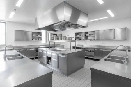 Cozinha industrial equipada com bancadas, pias e armários de aço inox para adequação sanitária