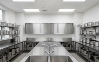 Pia inox sob medida com duas cubas em cozinha industrial equipada com bancadas e armários de aço inox