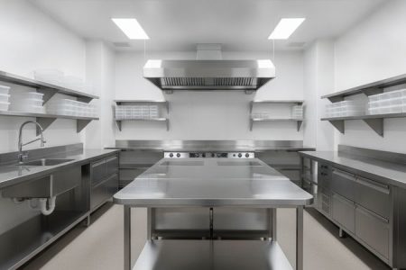 Cozinha industrial em aço inox equipada como dark kitchen com bancadas, coifa, prateleiras e pia industrial